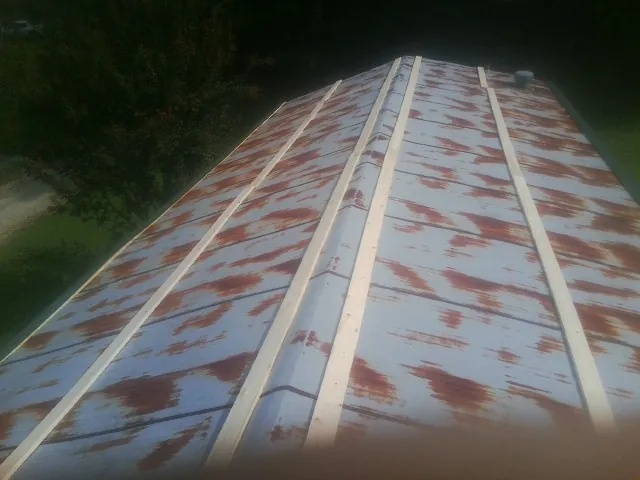 Rusted metal roof panels with new wood purlins before replacement — Storm Damage Roof Repair in Borup by Roofing Brothers