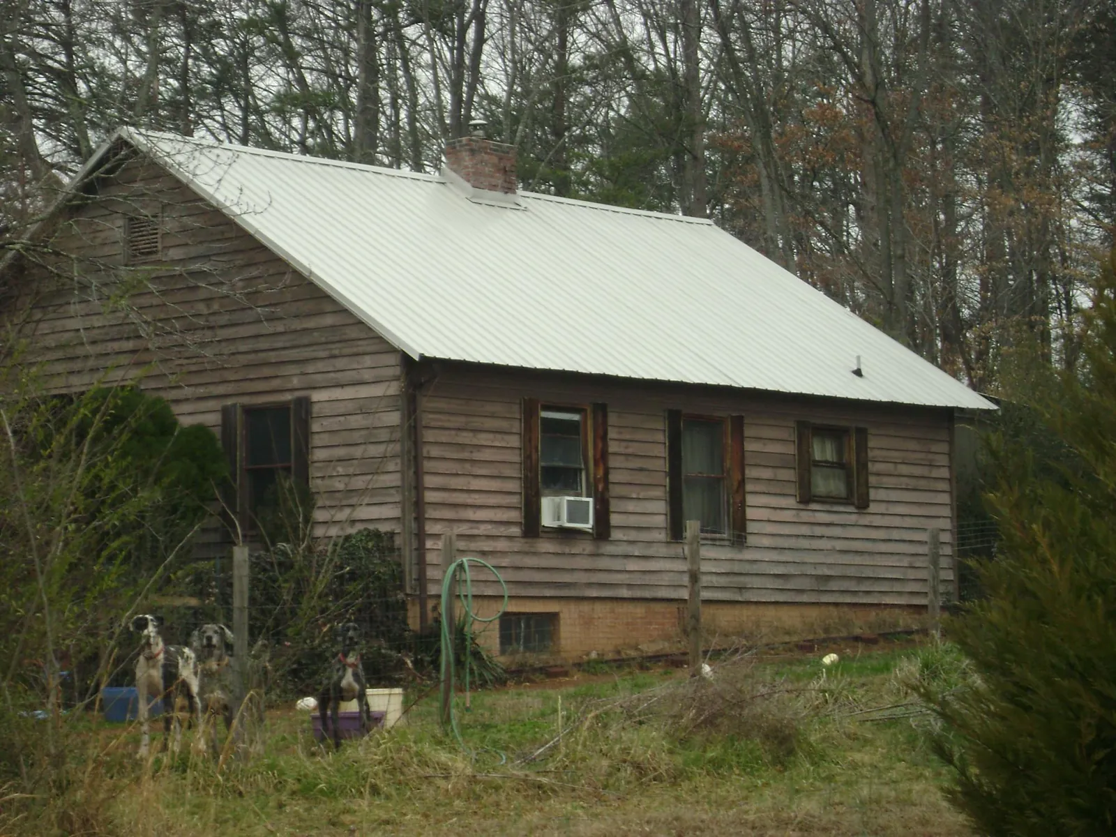 White metal roof on an old wood sided farmhouse, from a Metal Roof Installation job in Borup